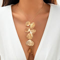 Gold shell design lariat necklace styled for coastal cowgirl beach outfits